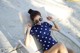 A woman in a polka dot swimsuit sitting on a beach chair.