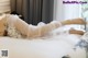 A woman in a wedding dress laying on a bed.