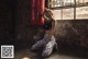 A woman squatting in front of a punching bag.