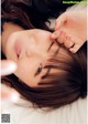 A woman laying on top of a bed with her eyes closed.