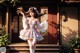 A woman in a white dress is dancing in front of a house.