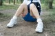 A woman sitting on the ground with her knee in pain.
