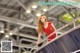 A woman in a red dress standing on an escalator.