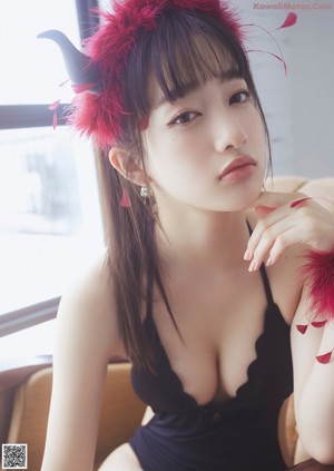 A woman in a black dress with red feathers on her head.